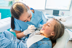 Dentist performing dental exam on a little girl at Poleski Family Dentistry.